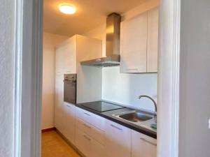 eine kleine Küche mit weißen Schränken und einer Spüle in der Unterkunft La Santa Azul in La Santa