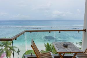 a balcony with a table and chairs and the ocean at Coral Grand Beach & Spa in Hulhumale