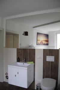 a bathroom with a white sink and a toilet at Apartment Exclusiv in Jena
