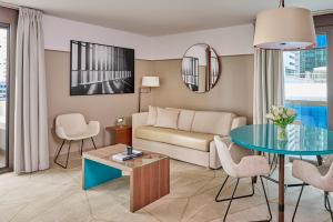 a living room with a couch and a table at Fraser Suites Paris La Défense in Courbevoie