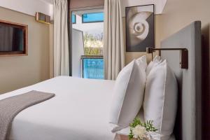 a bedroom with a white bed and a window at Fraser Suites Paris La Défense in Courbevoie