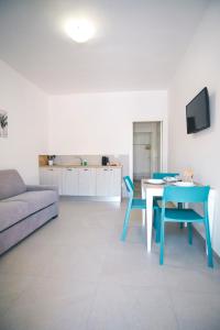 a living room with a couch and a table and chairs at Dal Monaco - casa blu in Castellana Grotte