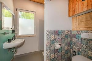 a bathroom with a sink and a toilet and a window at Albatros in Ueckeritz