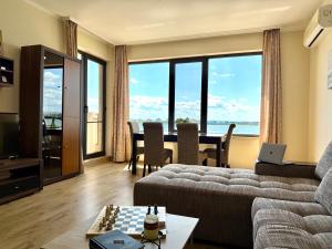 a living room with a couch and a table at Cosher - Gardenia Palace Apt 11 in Pomorie +23 photos