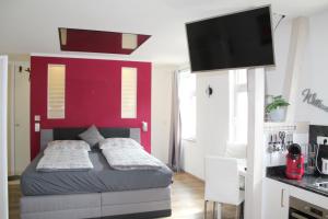 a bedroom with a bed with a red wall at Apartment Charmant in Jena