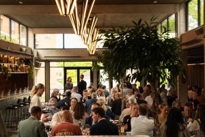 a crowd of people sitting at tables in a restaurant at Roberta's Society Aarhus in Aarhus