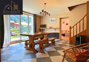 a dining room with a wooden table and a television at Maison tout confort avec jardin in Bonneville