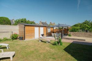 a backyard with a house with a fence at Maison à 1300 m des plages in Saint Malo