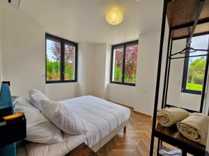 a bedroom with a bunk bed and two windows at L'appartement 1 by Vindihouses in Ressille