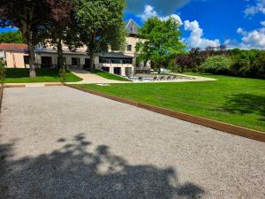 a shadow of a tree on the ground next to a building at L'appartement 1 by Vindihouses in Ressille