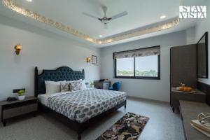 a bedroom with a king sized bed and a window at StayVista at Eleganza Villas & Resort, Jaipur in Jaipur
