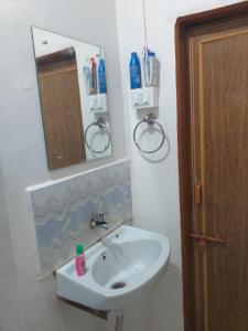 a bathroom with a white sink and a mirror at 2 BHK ENTIRE ROW HOUSE Home stay in nashik in Nashik
