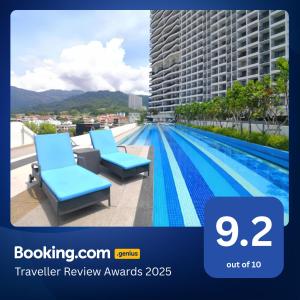 a picture of a swimming pool with two chairs on a balcony at The Landmark Penang in Tanjong Tokong