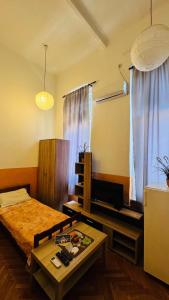 Un dormitorio con una cama, una mesa y un televisor. en Apartment Balkan, en Belgrado