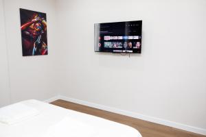 a room with a bed and a tv on the wall at Apartment in Chișinău, near the Airport in Chişinău