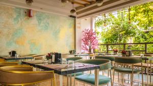 a restaurant with tables and chairs and a large window at Vilu Rest in Hulhumale