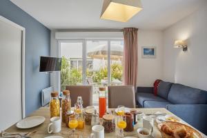 a dining room with a table with food on it at Résidence Odalys Nakâra in Cap d'Agde +102 photos