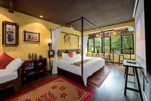 a bedroom with a bed and a desk and window at Old Quarter Art Boutique Family Suite Railside Respite in Hanoi