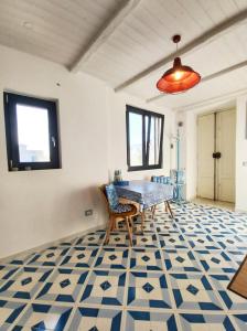 a dining room with a table and a blue and white floor at MinaMare Vacation Home in Torre Annunziata