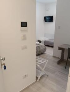 una porta che conduce a una camera con letto e tavolo di Affittacamere mezzaluna a San Benedetto del Tronto