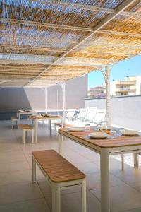 a room with tables and chairs and a straw roof at Dal Monaco - casa verde in Castellana Grotte