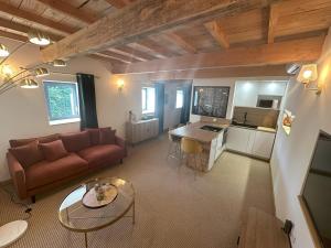 a living room with a couch and a table at Gîte de charme en Ardèche in Saint-Étienne-de-Fontbellon