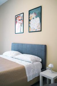 a bedroom with a bed with three pictures on the wall at Dal Monaco - casa verde in Castellana Grotte
