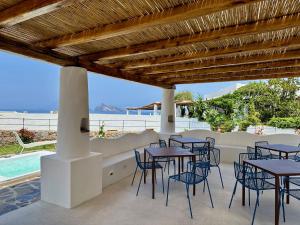 a patio with tables and chairs and a swimming pool at Kyma Suites in Panarea +35 photos