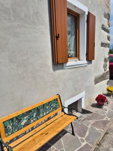 a wooden bench sitting in front of a window at Casa Regina 21 - Families & Friends Dolomites in Ponte delle Arche