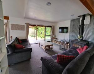 a living room with two couches and a fireplace at Okuti Retreat in Little River