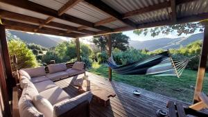 a hammock on a deck with a view of the mountains at Okuti Retreat in Little River