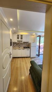 a kitchen with white cabinets and a couch in a room at Trend Suite Hotel in Uzungöl