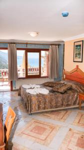 a bedroom with a large bed and a large window at Villa Symbola in Oludeniz