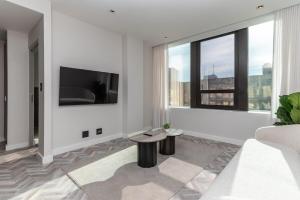 a living room with a couch and a tv at Modern City Unit with Aircon, CoWorkspace, Secure Building in Cape Town