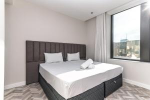 a bedroom with a large bed with a large window at Modern City Unit with Aircon, CoWorkspace, Secure Building in Cape Town