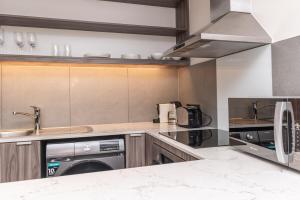 a kitchen with a sink and a dishwasher at Modern City Unit with Aircon, CoWorkspace, Secure Building in Cape Town