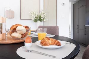 a table with a plate of bread and eggs and orange juice at Bosrijk Austerpark chalet 32 in Putten