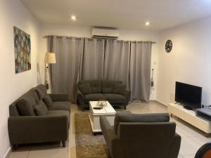 Una sala de estar con dos sofás y un televisor. en The Gallery homes- two bedroom, en Madina