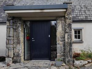 a blue door on a house with a stone wall at The Burren, Cozy Cottage, County Clare in Carran