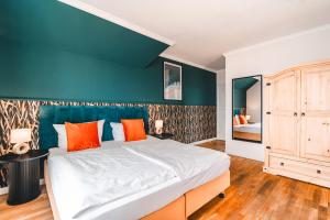 a bedroom with a large bed and a blue wall at Hotel Hüttmann in Norddorf
