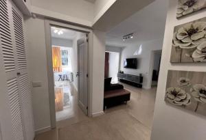 a hallway with a living room with a couch and a television at Cotroceni Prestigious in Bucharest