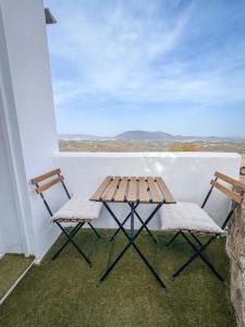 a picnic table and two chairs on a balcony at Loft Deluxe Torre del Pan in Olvera +5 photos