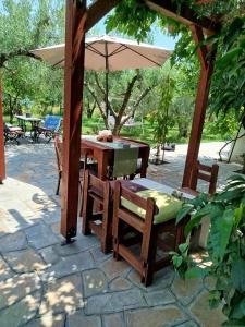 un patio con ombrellone, tavolo e sedie di Green Olive Studios 2 a Agios Mamas