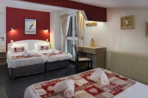 a hotel room with two beds and a desk at Hotel Le Stella in Châtel +10 photos