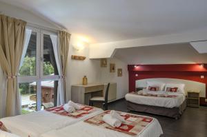 a hotel room with two beds and a desk at Hotel Le Stella in Châtel
