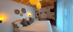 a bedroom with a large white bed with blue pillows at White Hotel in Oludeniz