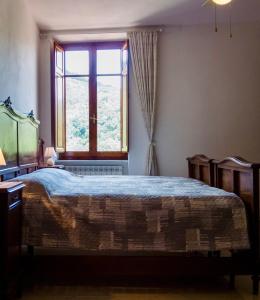 Un dormitorio con una cama grande y una ventana. en Casa Mirella, en Ameglia