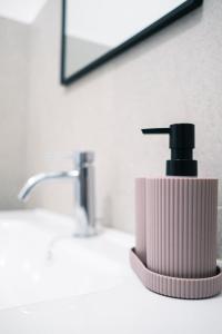 a bathroom sink with a black soap dispenser on it at Dal Monaco - casa blu in Castellana Grotte +14 photos