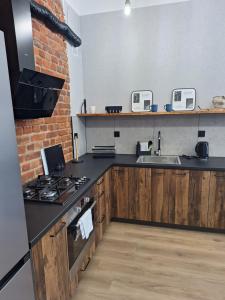a kitchen with a sink and a stove top oven at Apartamenty MILANHOUSE in Gołdap