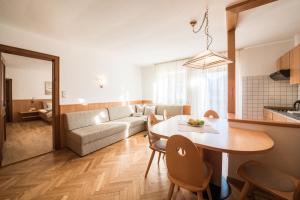 a living room with a table and a couch at Stammhaus Vetterer in Lana